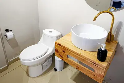 a bathroom with a white toilet and a sink at Luxury Home In Aguacatala in Medellín