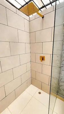 a shower with white tiled walls and a glass door at Luxury Home In Aguacatala in Medellín