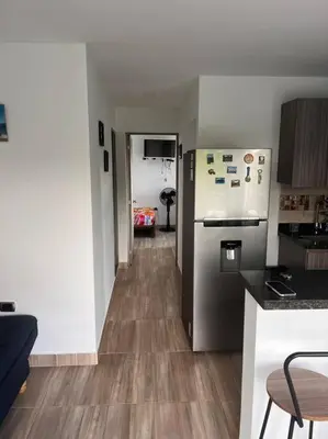a kitchen with a stainless steel refrigerator and wooden floors at Lindo apartamento en Guatapé in Guatapé