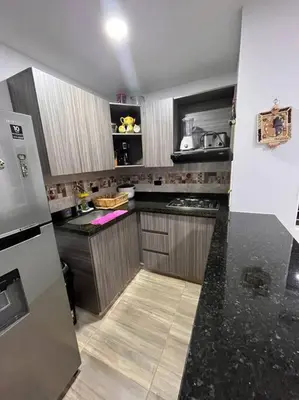 a kitchen with black counter tops and a refrigerator at Lindo apartamento en Guatapé in Guatapé