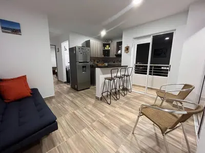 a living room with a couch and chairs and a kitchen at Lindo apartamento en Guatapé in Guatapé