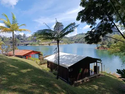 a small house on a hill next to a river at Marina Navegar in Guatapé