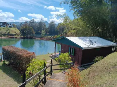 a small house on the side of a lake at Marina Navegar in Guatapé