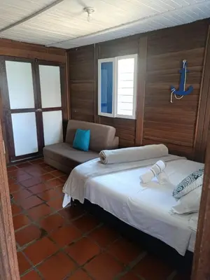 a bedroom with a bed and a couch and windows at Marina Navegar in Guatapé