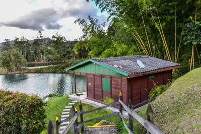 a small house on the side of a lake at Marina Navegar in Guatapé