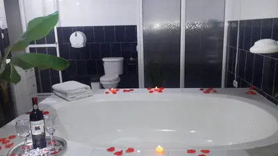 a bathroom with a bath tub with a toilet and candles at Magic Jardín Hostel - Patio, Balcony & Rooftop in Jardin