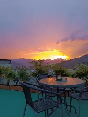 a table and chairs on a balcony with a sunset at Magic Jardín Hostel - Patio, Balcony & Rooftop in Jardin