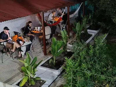 a group of people sitting at a table in a restaurant at Magic Jardín Hostel - Patio, Balcony & Rooftop in Jardin