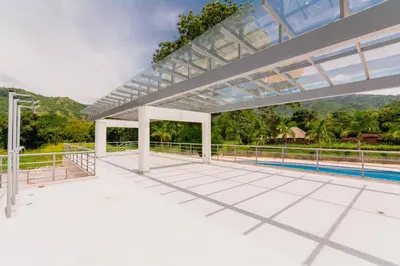 a large white patio with a pool in the background at Apartasol Dominica Citadela Di Sole in Santa Fe de Antioquia