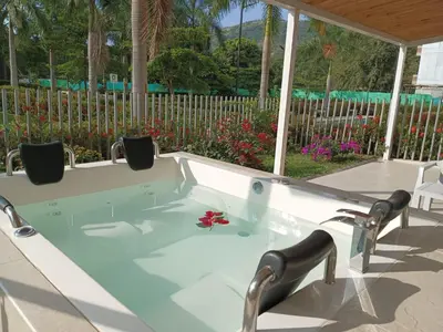 a jacuzzi tub in a yard with a fence at Apartasol Dominica Citadela Di Sole in Santa Fe de Antioquia