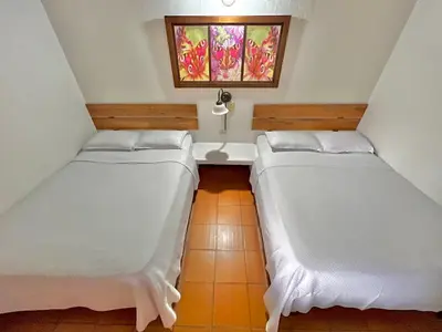 two beds in a small room with a window at HOTEL MONTE VERDE in Concordia