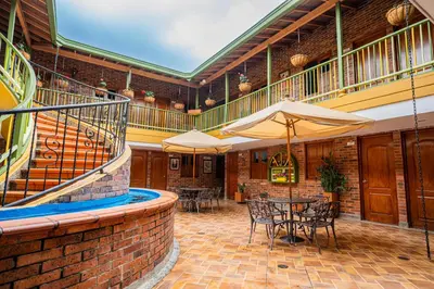 a patio with tables and umbrellas in a building at HOTEL MONTE VERDE in Concordia
