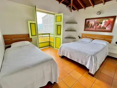 a bedroom with two beds and a balcony at HOTEL MONTE VERDE in Concordia