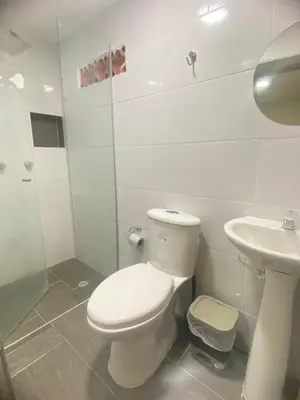 a white bathroom with a toilet and a sink at 23 BELO APARTAMENTO CON BALCON EN LAURELES ESTADiO 2 HAB 2 BAÑOs in Medellín