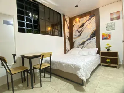 a bedroom with a bed and a table and chairs at 23 BELO APARTAMENTO CON BALCON EN LAURELES ESTADiO 2 HAB 2 BAÑOs in Medellín
