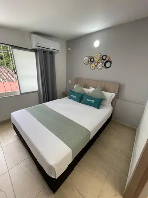 a bedroom with a large white bed with blue pillows at Hotel 12 Nights in Medellín