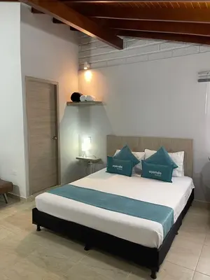 a bedroom with a large bed with blue pillows at Hotel 12 Nights in Medellín