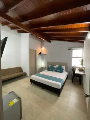 a bedroom with a large bed and a desk at Hotel 12 Nights in Medellín