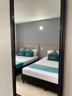a mirror reflecting two beds in a room at Hotel 12 Nights in Medellín