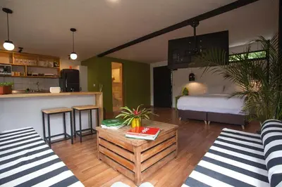 a living room with a bed and a room with a table at The TREE house in Envigado