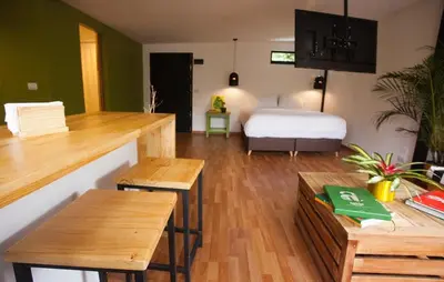 a bedroom with a bed and wooden tables and benches at The TREE house in Envigado