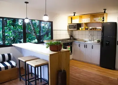 a kitchen with a refrigerator and a counter with stools at The TREE house in Envigado
