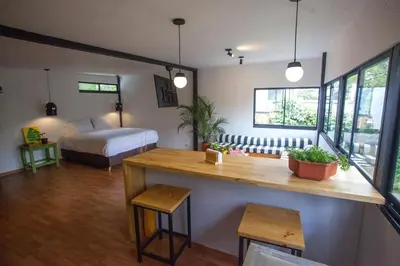 a room with a bedroom with a bed and a desk at The TREE house in Envigado