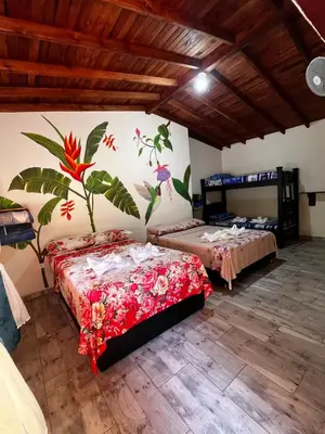 two beds in a room with a mural on the wall at Hotel La Sultana in Jardin