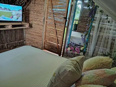 a bed in a room with a tv and a window at Finca Alto Bonito in Doradal