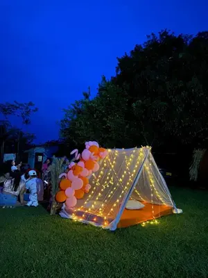 a tent with balloons in the grass at night at Finca Alto Bonito in Doradal