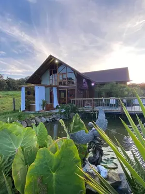 a house with a pond in front of it at Chalet del lago Santa Elena in Santa Elena