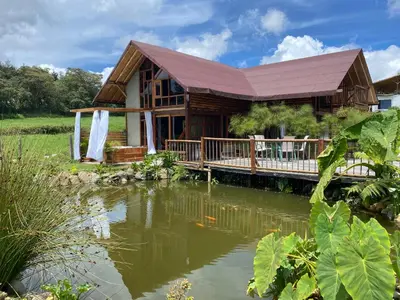 a log cabin with a pond in front of it at Chalet del lago Santa Elena in Santa Elena