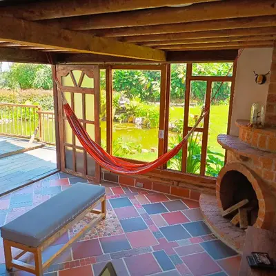 a hammock in a screened in porch with a fireplace at Chalet del lago Santa Elena in Santa Elena