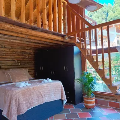 a bedroom with a bed under a wooden staircase at Chalet del lago Santa Elena in Santa Elena