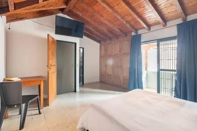 a bedroom with a bed and a desk and a window at Letto Hostal in Rionegro
