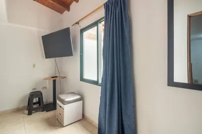 a room with a window with a blue curtain at Letto Hostal in Rionegro