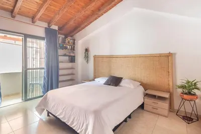 a bedroom with a large bed and a large window at Letto Hostal in Rionegro