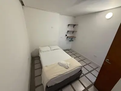 a small room with two beds and a shelf at Road Living Home in Medellín