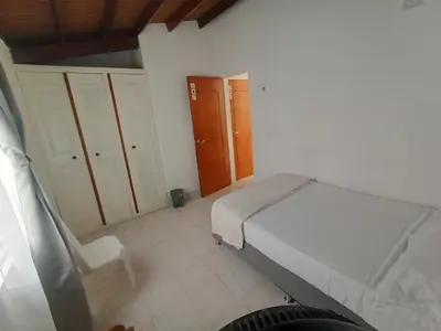 a bedroom with a bed and a chair in it at Road Living Home in Medellín