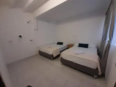 two beds in a room with white walls at Road Living Home in Medellín