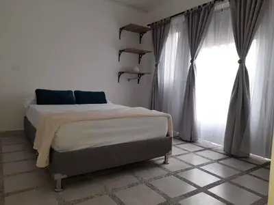 a bedroom with a bed and a large window at Road Living Home in Medellín