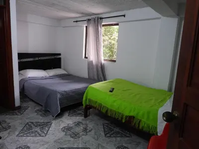 a small bedroom with a bed and a window at Casa Hotel Los Faroles- Samaná/Caldas in Samaná