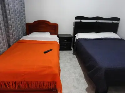 a bedroom with two beds with orange sheets at Casa Hotel Los Faroles- Samaná/Caldas in Samaná