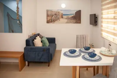 a living room with a blue chair and a table at Apartamento Duplex - Aqua Guatape in Guatapé