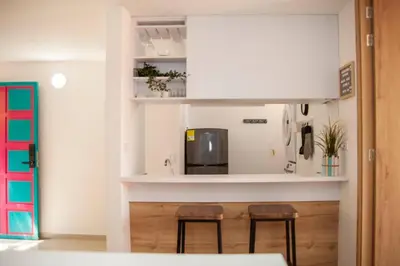 a kitchen with two chairs and a microwave at Apartamento Duplex - Aqua Guatape in Guatapé