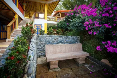 a bench sitting on a stone wall next to flowers at Hotel Terra Belén in Belén de Umbría