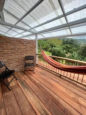 a room with a hammock on a wooden deck at Hotel Terra Belén in Belén de Umbría