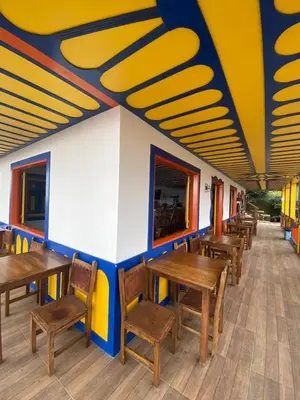 a row of wooden tables and chairs in a restaurant at Hotel Terra Belén in Belén de Umbría