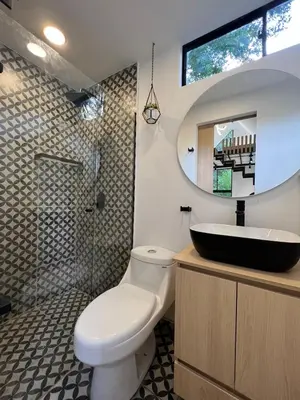 a bathroom with a toilet and a sink and a mirror at Mini Casa en Poblado Medellín FRN109 By Roots Rentals in Medellín