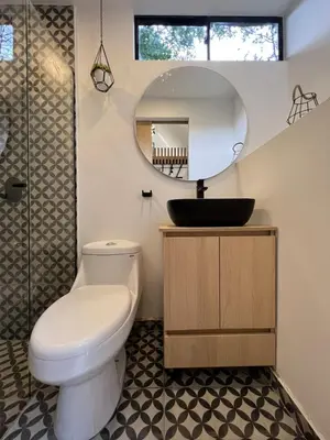 a bathroom with a toilet and a sink and a mirror at Mini Casa en Poblado Medellín FRN109 By Roots Rentals in Medellín